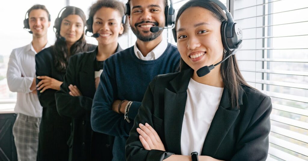 A diverse group of smiling call center agents in an office setting.